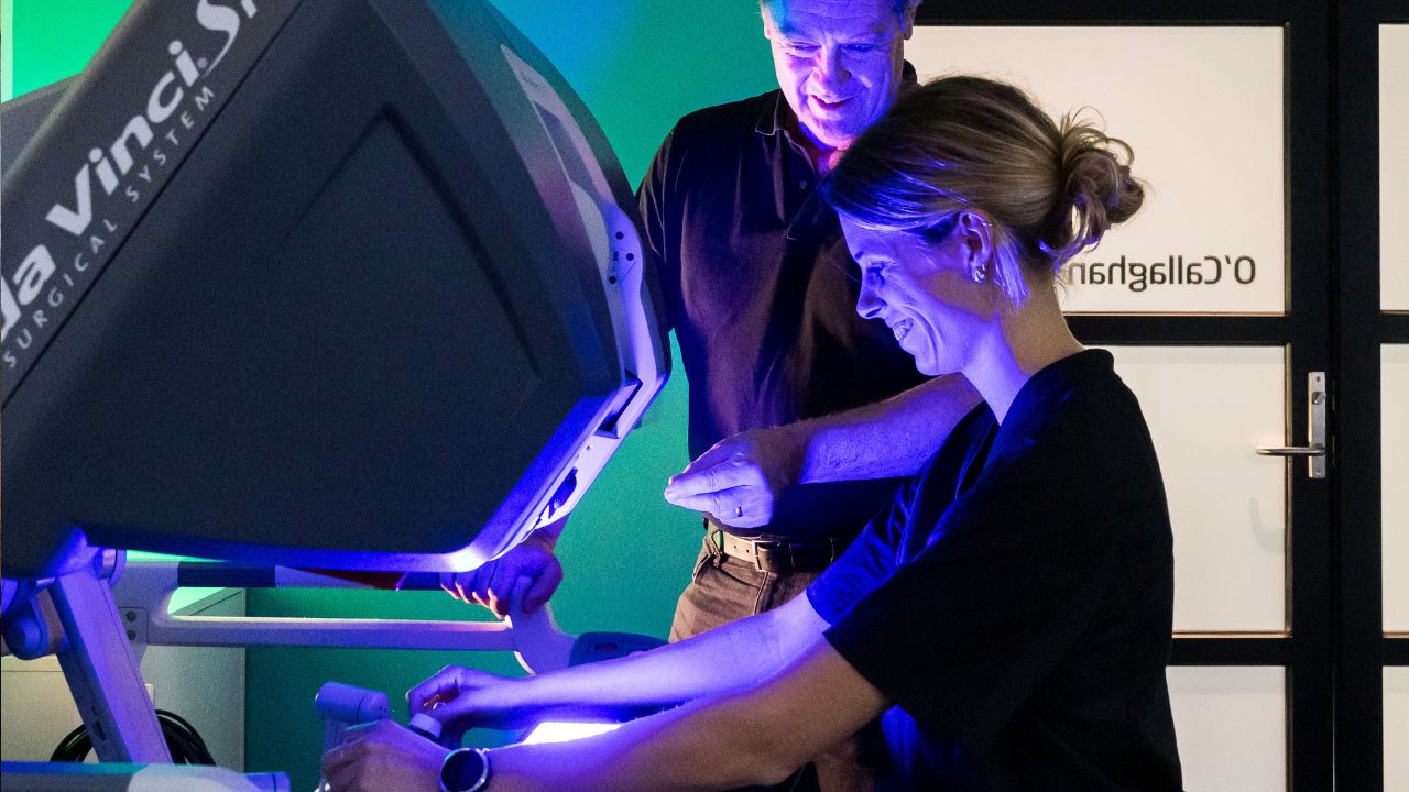 Two people operating a robotic surgical system