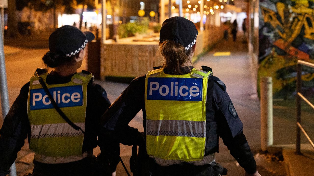 Two police officers walking down a city street in the evening